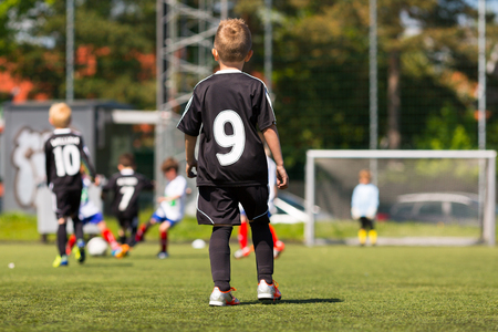 Kids playing soccer outdoors on a sunny day. Trademarks have been removed.の写真素材
