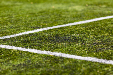 Close-up of artificial green soccer turf on a sunny day.