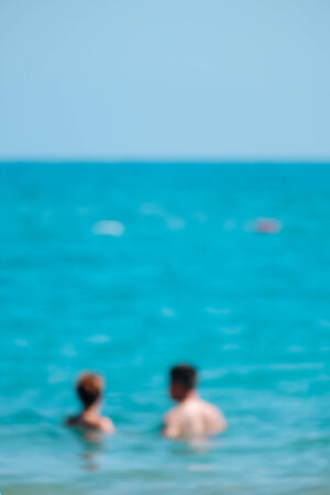 Blurred couple with the ocean in the background.の写真素材