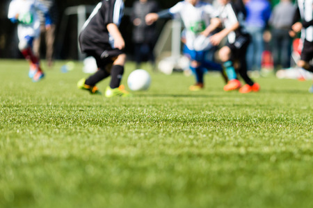 Picture of kids soccer training match with shallow depth of field. Focus on foreground.の写真素材