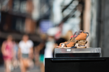 A shoe with high heel on display outside a footwear store.の写真素材