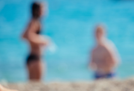 Blurred couple with the ocean in the background.の写真素材