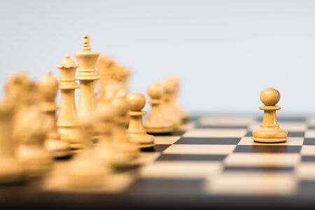 Studio shot of chess game with chess pieces on white background.