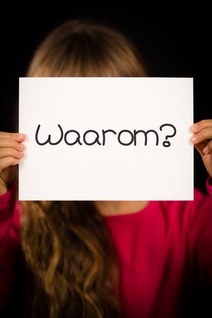 Studio shot of child holding a sign with Dutch word Waarum - Whyの写真素材