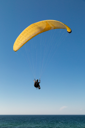 Single paraglider hovering in the sky on a sunny day.の写真素材