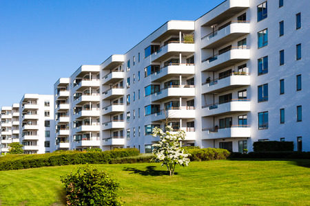 Contemporary white residential building against a blue sky. Ideal for illustration of real estate or investment concepts.の写真素材