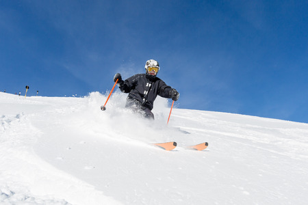 Male skier skiing in fresh snow on ski slope on a sunny winter day at the ski resort Soelden in Austria.の写真素材