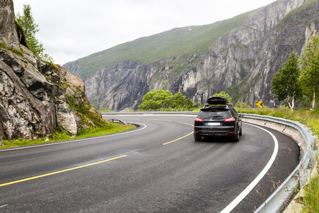 Car driving on the Riksvei 7 public road crossing the large Hardangervidda plateau in Western Norway.の写真素材