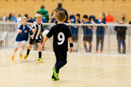Young northern european boys playing a indoors soccer training match inside an indoor sports arena.の写真素材