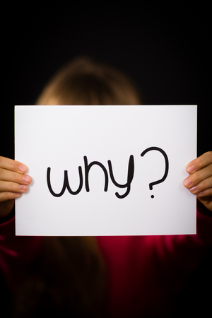 Studio shot of child holding a Why sign made of white paper with handwriting.の写真素材