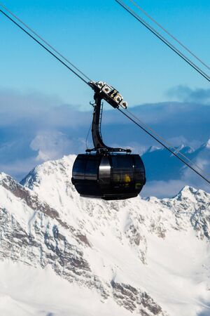 Gondola ski lift at ski resort with mountains and snow in the background.の写真素材