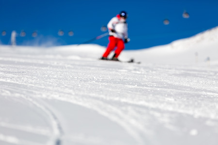 Blur of male skier skiing in fresh snow on ski slope on a sunny winter day at the ski resort Soelden in Austria.の写真素材