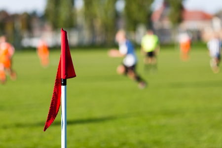 Shallow depth of field shot of group of male soccer players playing amateur soccer match on sunny summer day on simple sports venue in Denmark.の写真素材