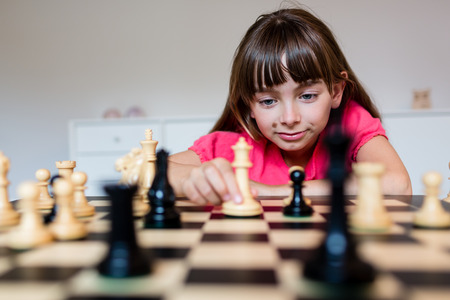 Young white child playing a game of chess on large chess board.の写真素材
