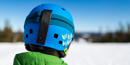 Close-up of young male skier standing on ski piste at ski resort on sunny winter day.の写真素材