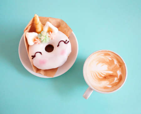 Unicorn donut with coffee on blue background. Top view. Flat layの写真素材