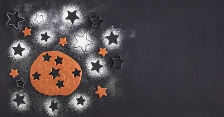 Gingerbread christmas cookies preparation. Top view. The Ingredients on a black table. Stars shapeの写真素材