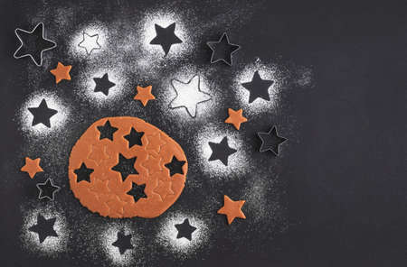 Gingerbread christmas cookies preparation. Top view. The Ingredients on a black table. Stars shapeの写真素材