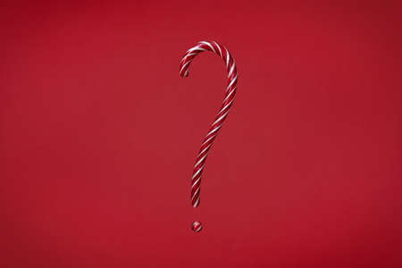 Candy cane question mark on red background. Christmas striped candieの写真素材