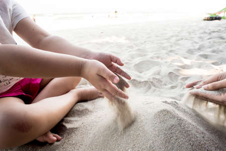 Children's play sand, Young girl molds of sand on the beach.の写真素材