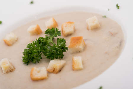 Mushroom cream soup with herbs and spices over rustic wooden backgroundの写真素材