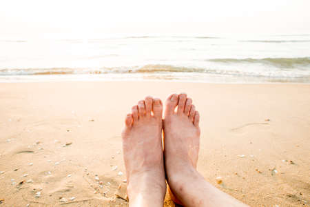 Tanned feet with pedicure with white Sands and the turquoise seaの写真素材