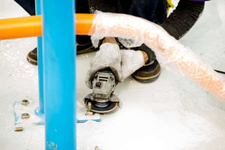 Arms holding grinder cutting concrete,worker cuts the steel, side view.の写真素材