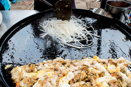 Phad Thai seafood - stir-fried rice noodles with prawns, soya bean sprouts and coriander leaves in the wok, traditional thai foodの写真素材