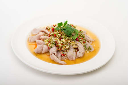 Thai Spicy Lime Salad with Pork, close up spicy pork served with chili sauce , fresh lime on top and fresh kaleの写真素材