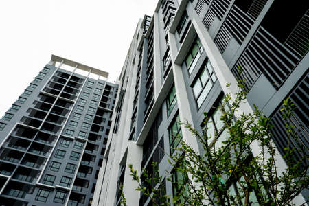 A modern high rise condominium tower rising into a clear blue skyの写真素材