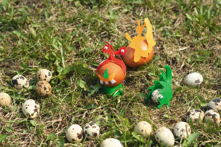 Some painted Easter eggs on the lawn. Joke photo with chiken and quail eggs, some of them decorated...