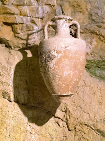 Ancient amphora on the wall. Museum collection of Pula Arena, Croatia, in bright light.のeditorial素材