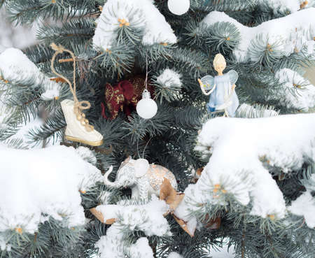 Blue fir-tree is decorated by Christmas toys. Elephants, angel, ball and scates. Christmas...