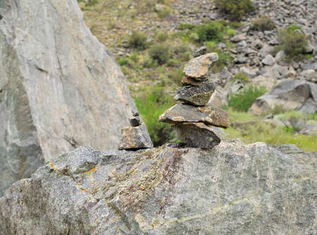 Rock cairn in the background of mountain slop, texture. Stones with lichen. Wet and cloudy weather....