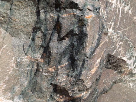 Rock with sharp edges, texture. Summer time, sunny weather, daylight, vibrant colors, warm tint.