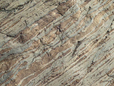 Grey strips on the surface of the stone. Stripped pattern, daylight.