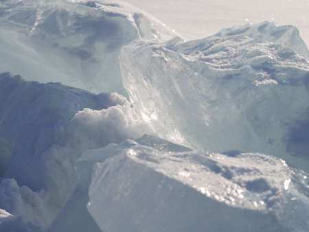 Ice cobblestones in the daylight. Ice surface with snow in the backlight. Daylight, natural texture....