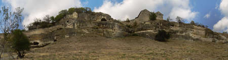 Chufut-Kale - medieval city-fortress in the Crimean Mountains that now lies in ruins. It is a national monument of Crimean Karaites culture close to Bakhchisaray. The front part of the wall of the cave city, two kenassa buildings on the front plan. Historのeditorial素材