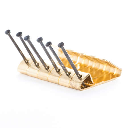 A small collection of brass picture hooks, with steel nails.の写真素材