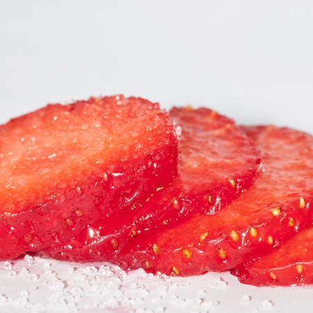 A row of sliced stawberry, covered in sugar.の写真素材