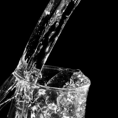 A black and white shot of water flowing into a wine glass.の写真素材