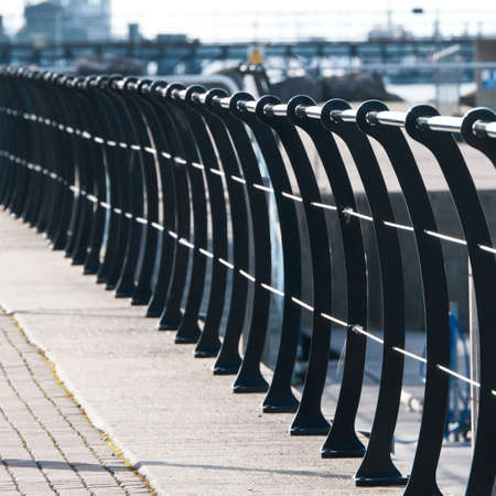 A metal fence with curved fenceposts reaches into the distance.の写真素材