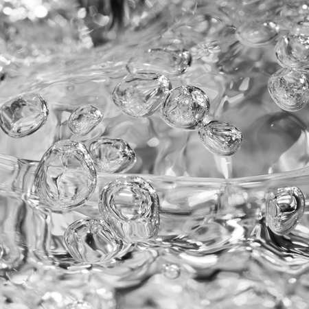 A abstract shot of water flowing quickly into a glass.の写真素材
