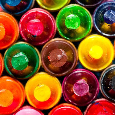 An macro shot of a stack of colourful crayons.