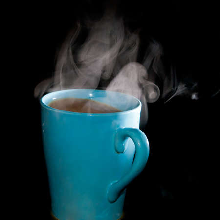 A close-up of steam rising from a hot cup of coffee.の写真素材