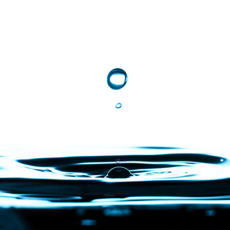 Water droplets falling into a bowl of water.の写真素材