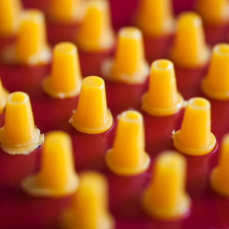 A macro shot of a red solitaire board full of yellow pegs の写真素材