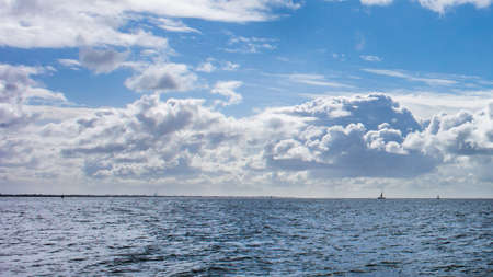 Looking at a yacht on the horizon from Calshot beach の写真素材