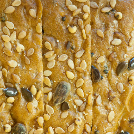 A macro shot of three slices of seeded bread の写真素材