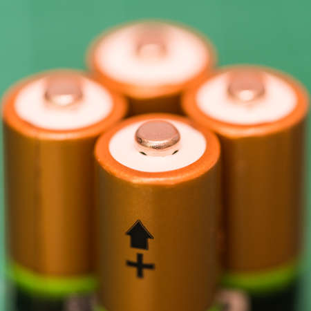 A macro shot of the positive terminals of a foursome of batteries.の写真素材